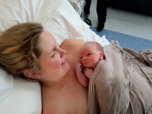 Newborn baby laying on mum's chest in hospital after birth