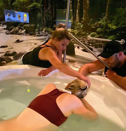 Pregnant mum labouring in birth pool at birth centre with birth partners comforting her