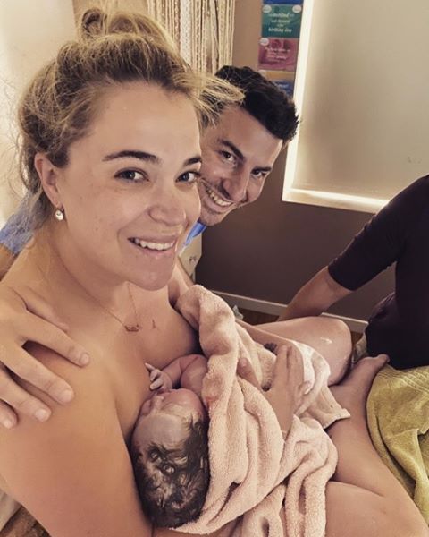 mum and partner smiling after birthing baby at home in bedroom