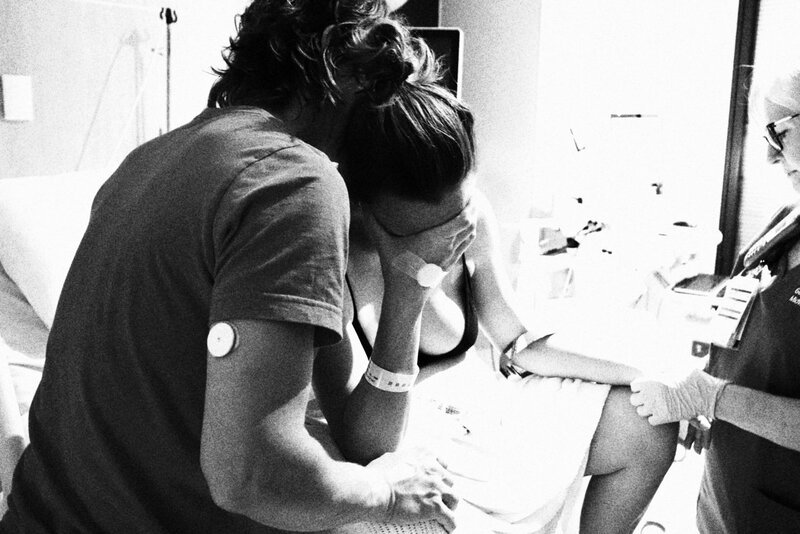 Pregnant mum in labour with partner by her side supporting