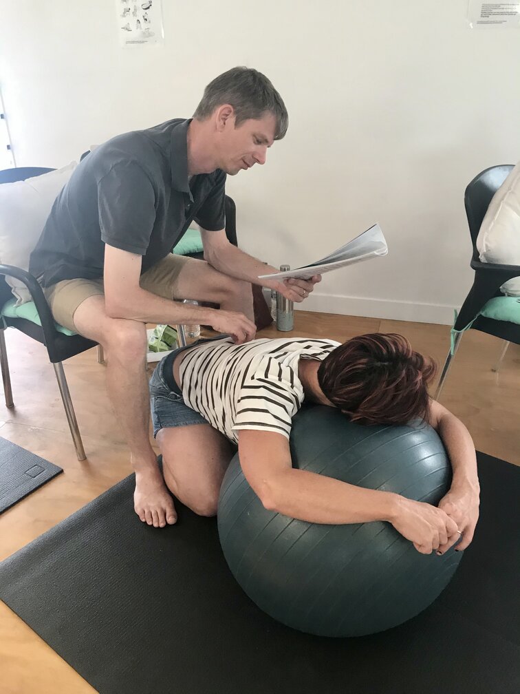 Partner reading hypnobirthing prompts to pregnant mum in hypnobirthing class