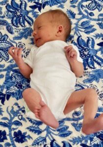 baby lying on blue patterned rug