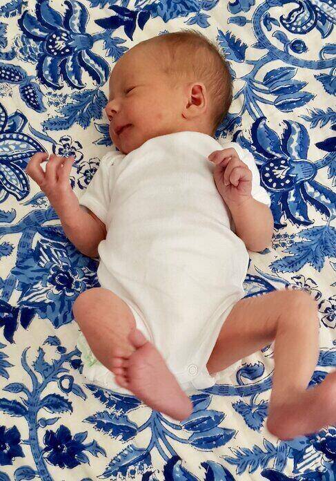 baby lying on blue patterned rug