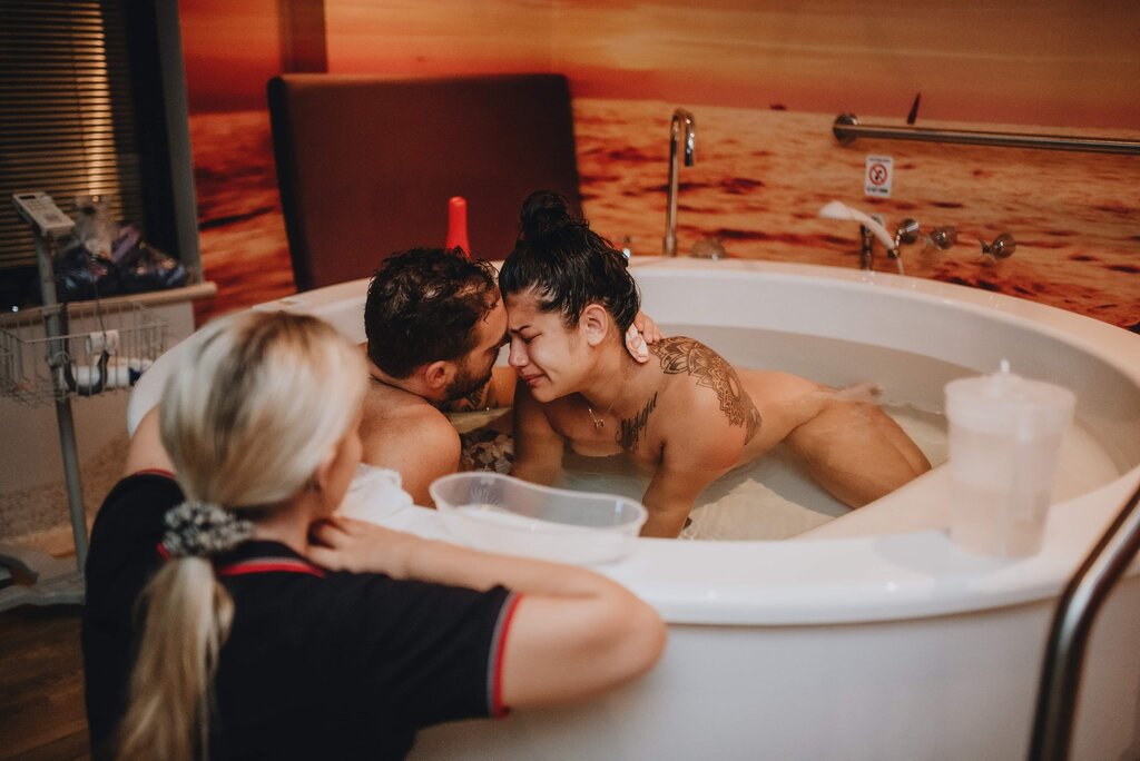 pregnant mum in birth pool with partner in labour at birth centre