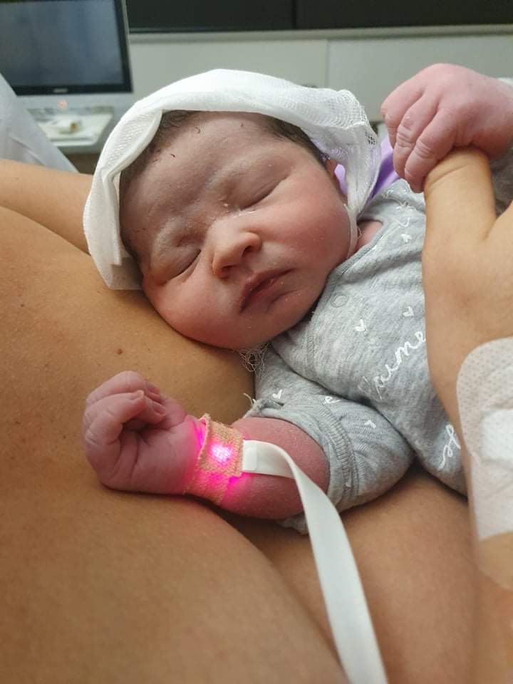 Baby lying on mum's chest sleeping