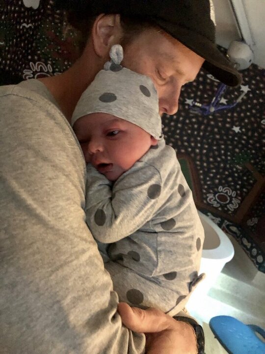 Dad cuddling newborn baby 