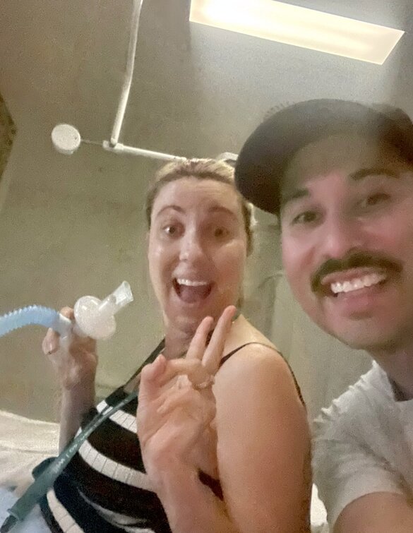 Pregnant couple smiling and in labour and mum using gas and air