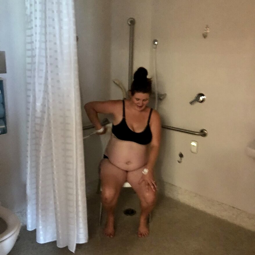pregnant mum sitting on chair in hospital shower