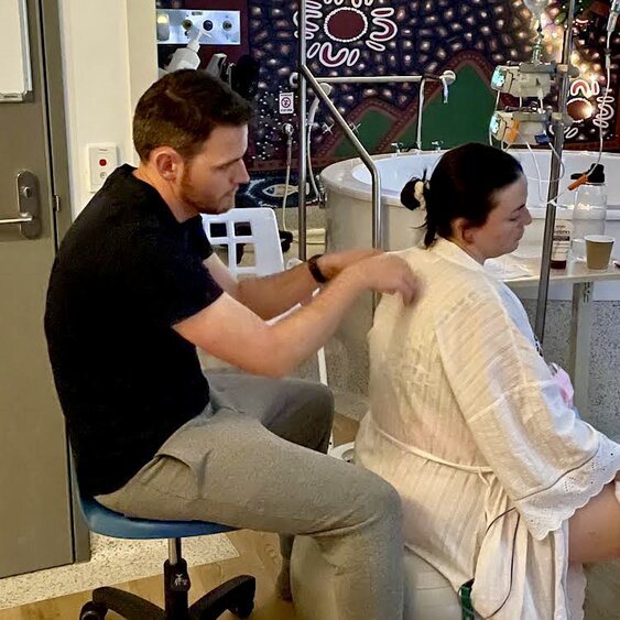 Partner applying light touch massage to pregnant mum in labour at birth centre
