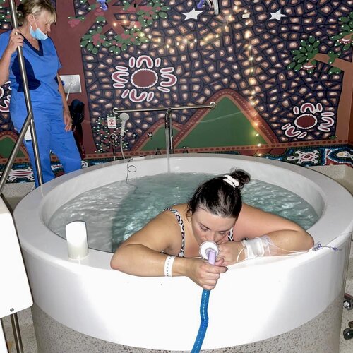 Pregnant mum in birth pool using gas and air at birth centre