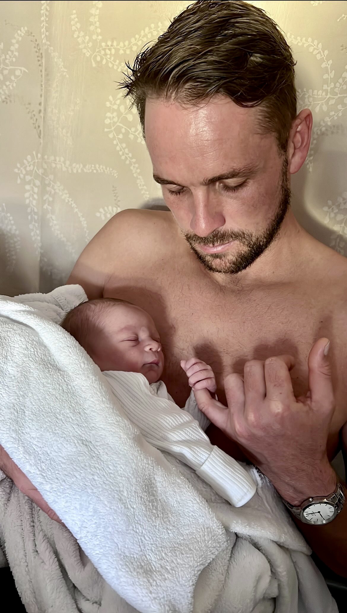 Mum holding wrapped up newborn baby