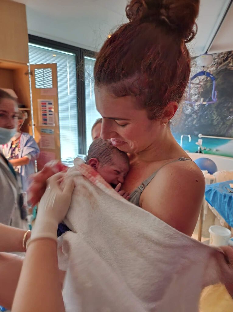 mum standing and holding baby with just after birthing