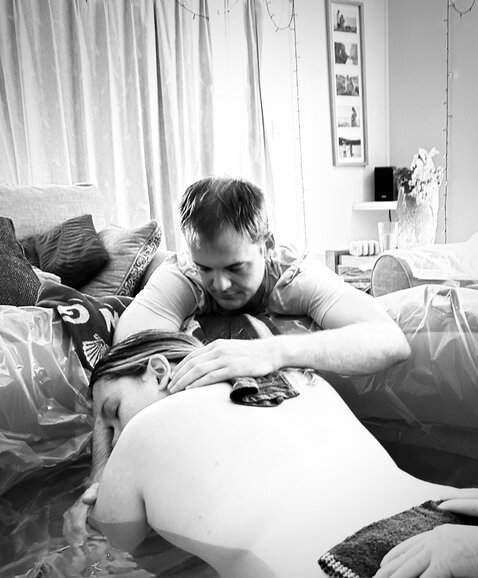 Partner comforting pregnant mum while she's in birth pool