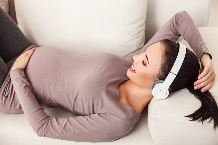 pregnant woman listening to hypnobirthing tracks