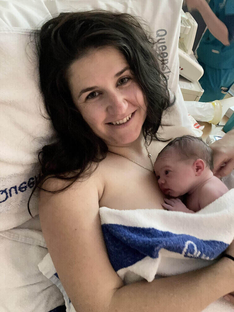 Mum in hospital bed with newborn baby skin to skin on chest