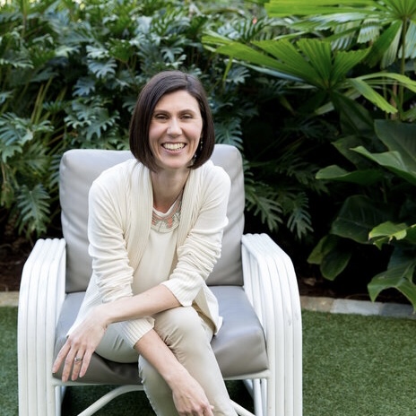 woman sitting on pale pink armchair