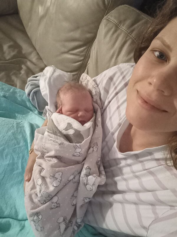 Mum holding newborn baby at home