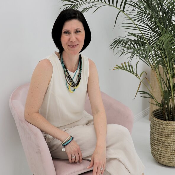woman sitting on pale pink armchair