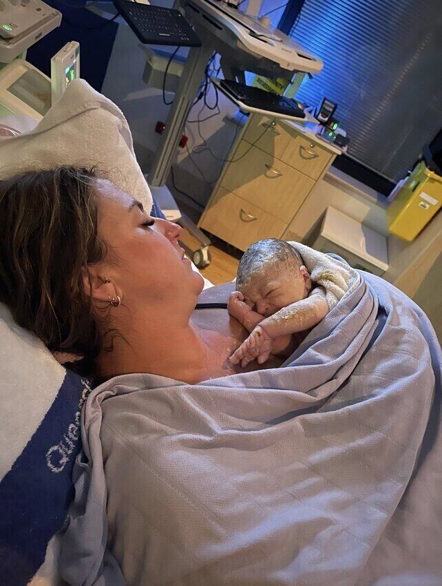 Mum holding baby in hospital bed 