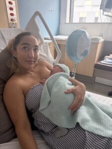 Mum sitting in hospital bed holding her newborn baby