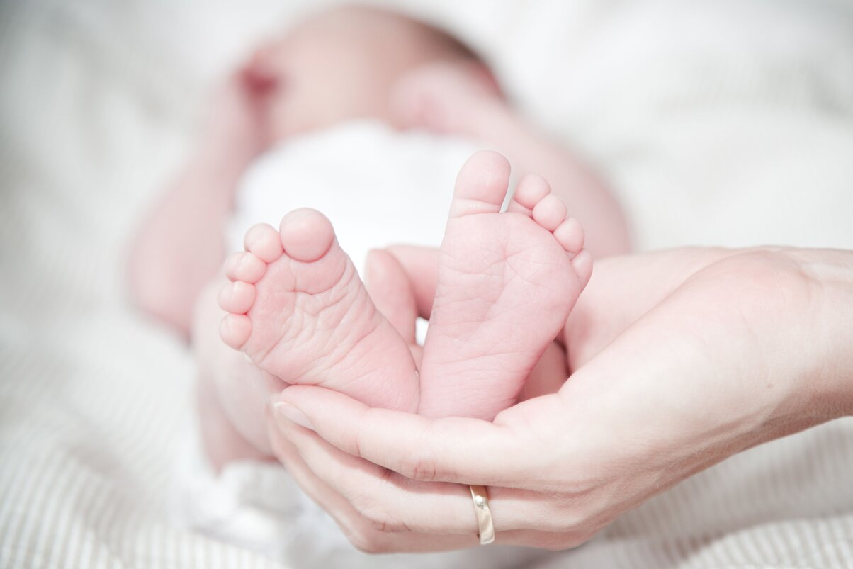 Parent cradling their newborn's feet after a calm natural hospital birth