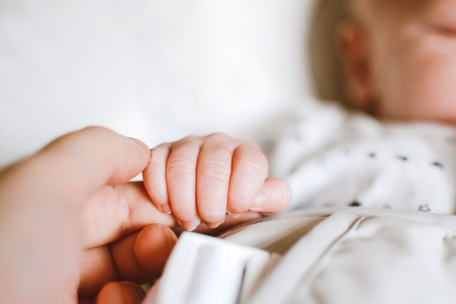 Newborn baby gripping a parent's finger after a positive hypnobirthing birth