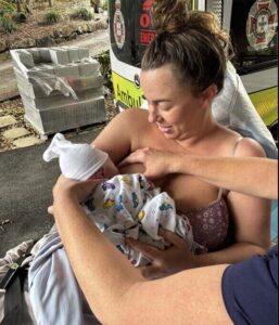 Brooke breastfeeding her newborn daughter beside the ambulance after her fast, unplanned home birth