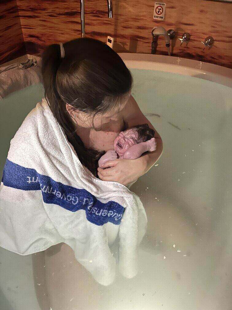 Mum holding her newborn in the birth pool after a calm hypnobirthing water birth
