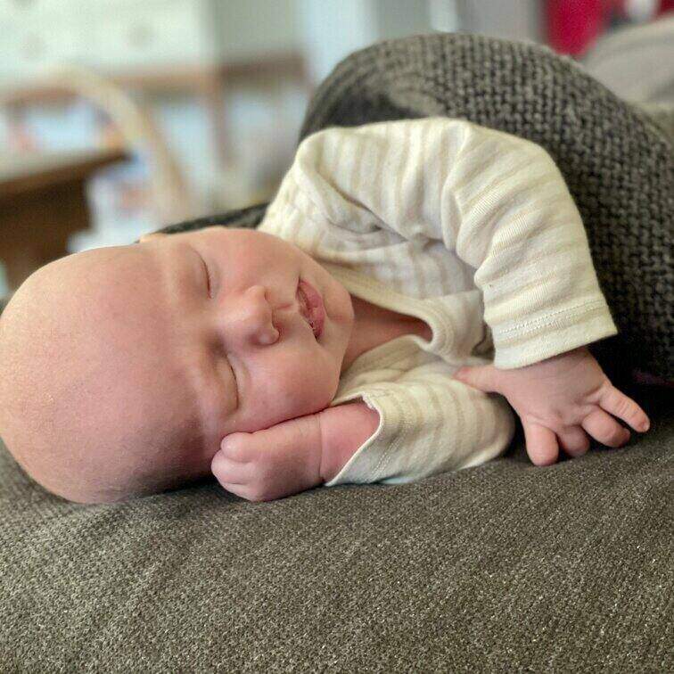 New born baby sleeping peacefully on their arm